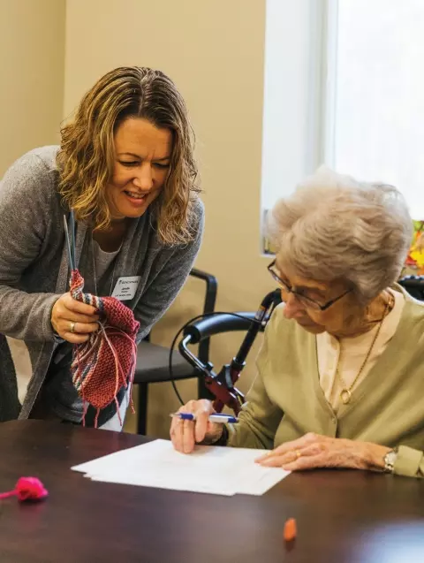 Senior living staff helping resident with activities
