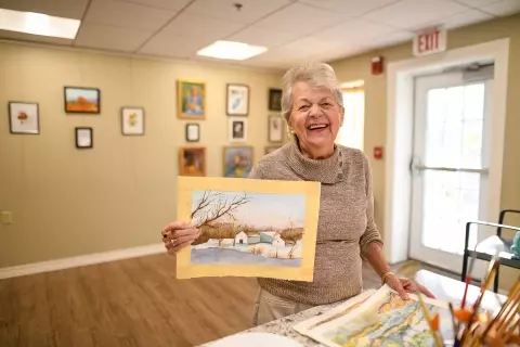 Senior woman holding painting