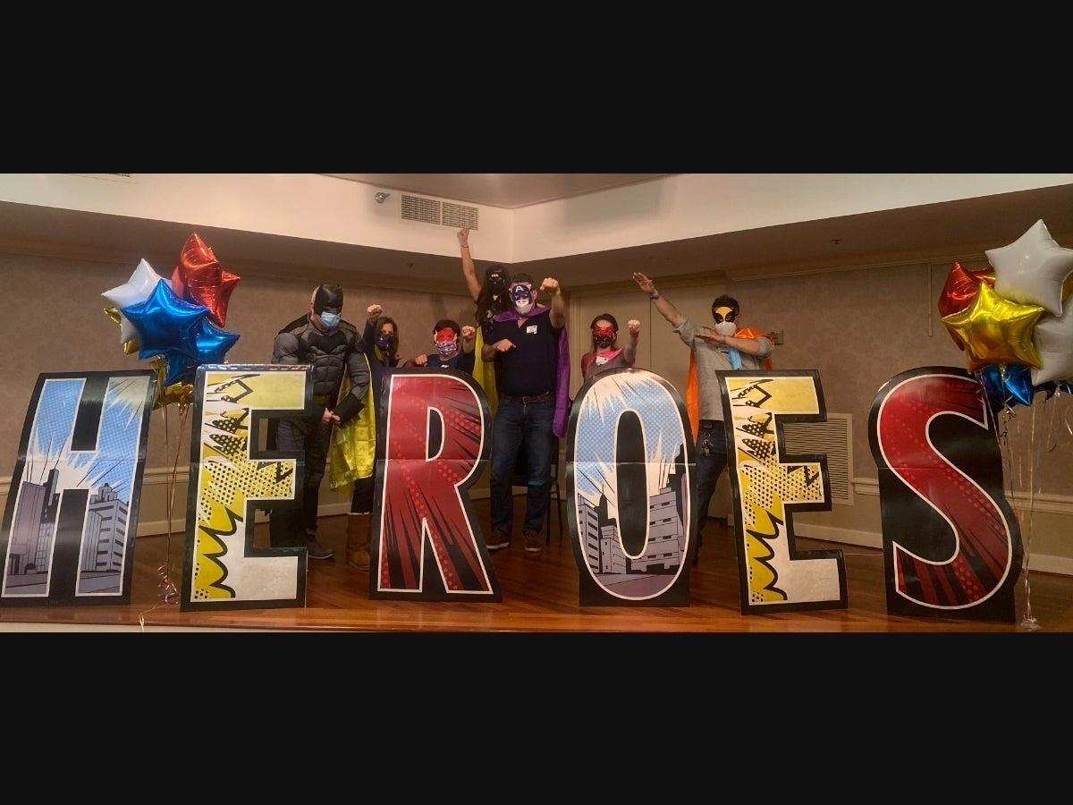 Associates dressed as superheroes
