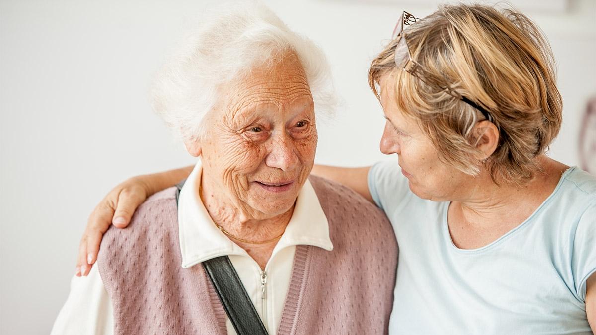 Adult daughter and senior woman hugging